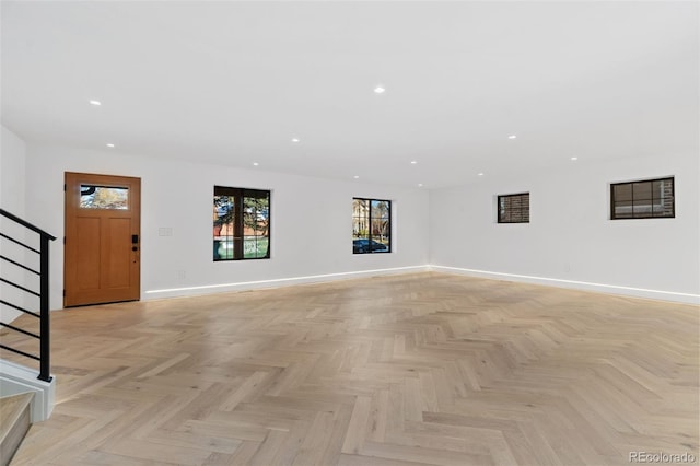 unfurnished living room featuring stairway, recessed lighting, and baseboards