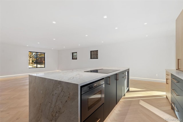 kitchen featuring recessed lighting, baseboards, modern cabinets, and a center island