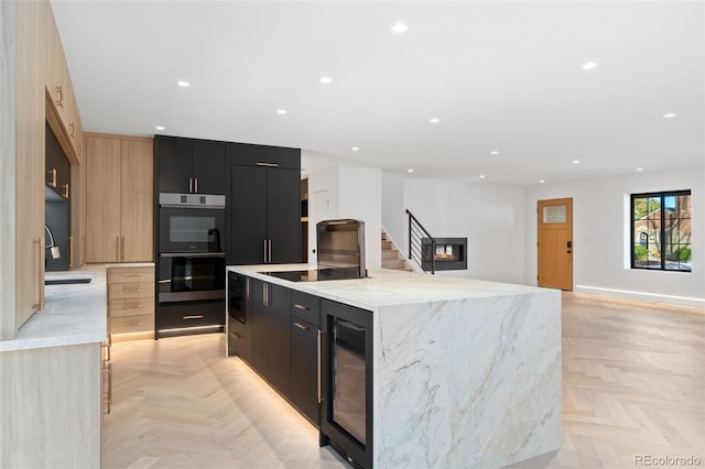 kitchen featuring wine cooler, double oven, modern cabinets, and dark cabinets