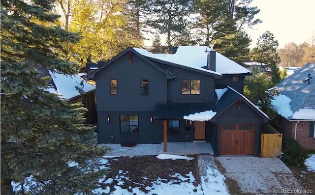 view of front of property with a garage, a chimney, and stucco siding