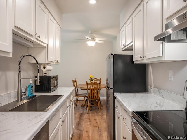 309 E Highline Cir Unit 104, Centennial, CO 80122 - kitchen featuring under cabinet range hood, electric range, ceiling fan, white cabinetry, and light wood finished floors