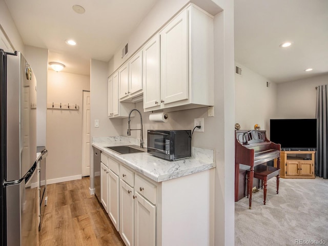 309 E Highline Cir Unit 104, Centennial, CO 80122 - kitchen with appliances with stainless steel finishes, white cabinetry, recessed lighting, and light stone counters