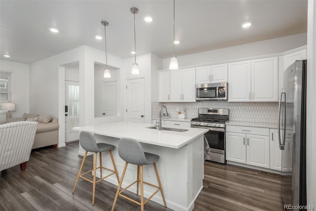 3365 N Coolidge Way, Aurora, CO 80019 - kitchen with appliances with stainless steel finishes, a sink, open floor plan, white cabinetry, and recessed lighting