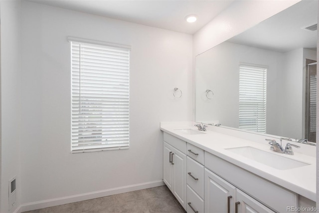 3365 N Coolidge Way, Aurora, CO 80019 - bathroom featuring double vanity, baseboards, an enclosed shower, and recessed lighting