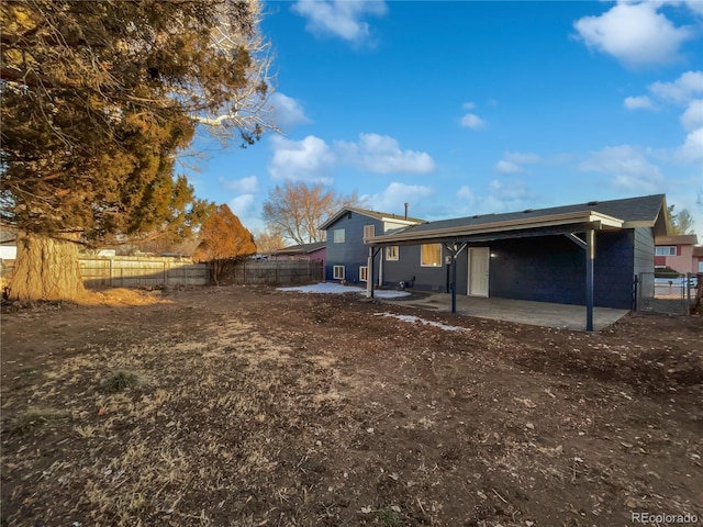 rear view of property featuring a patio area and a fenced backyard