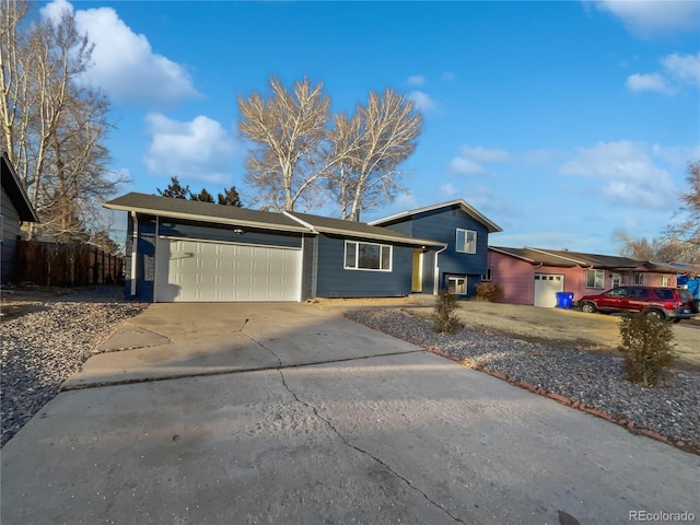 view of front of house with a garage, driveway, and fence