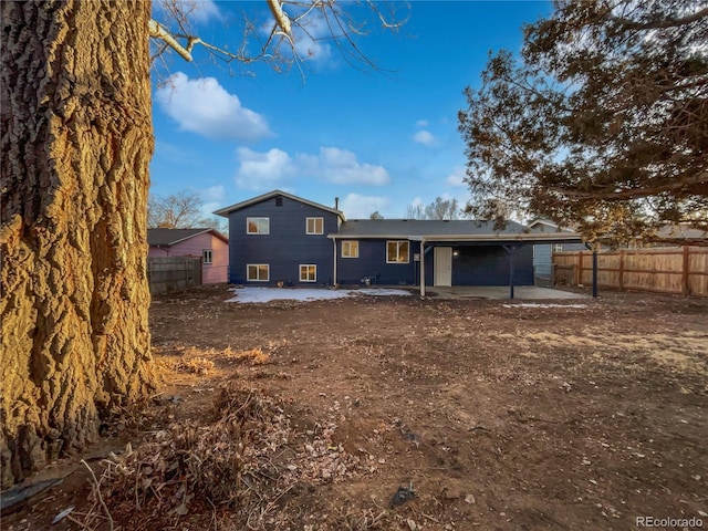 back of property with a patio area and fence