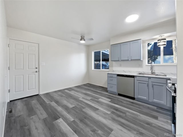 kitchen featuring wood finished floors, a sink, light countertops, gray cabinets, and dishwasher