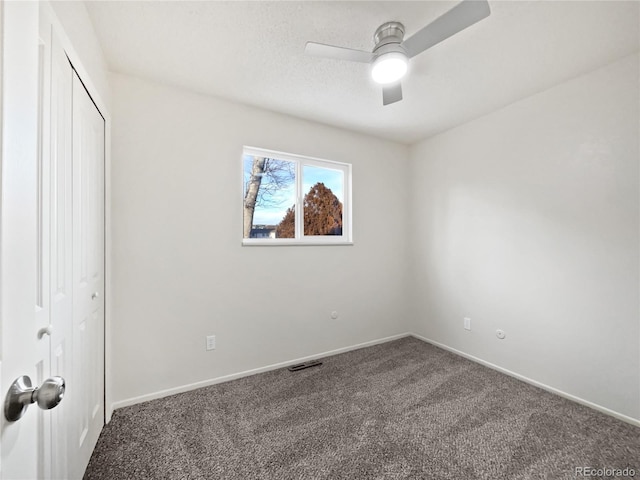 unfurnished bedroom featuring carpet floors, a ceiling fan, baseboards, and a closet