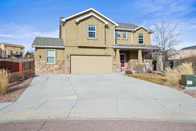 craftsman inspired home with stucco siding, fence, stone siding, covered porch, and an attached garage