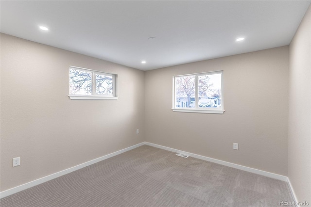 spare room with baseboards, visible vents, carpet flooring, and recessed lighting