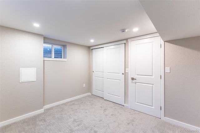 below grade area with recessed lighting, light carpet, and baseboards