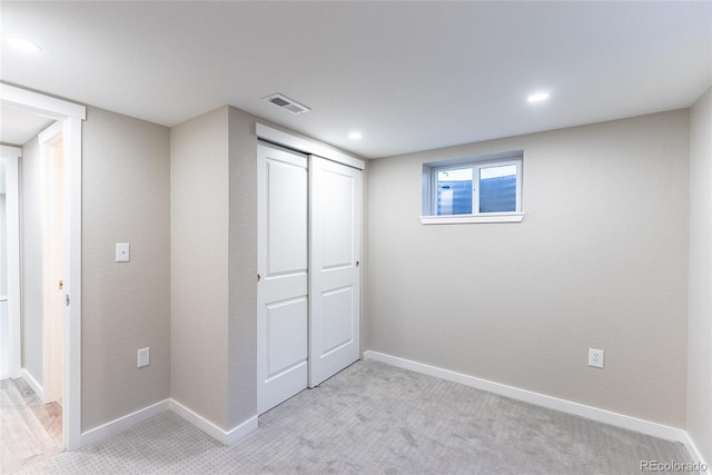 unfurnished bedroom with a closet, visible vents, light carpet, and baseboards