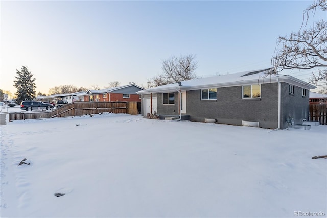 view of front of home featuring brick siding and fence