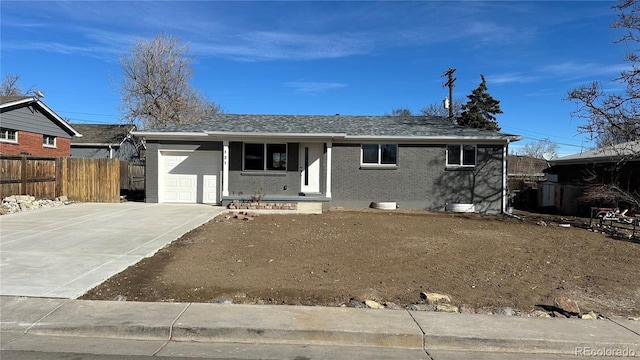 single story home with brick siding, driveway, an attached garage, and fence