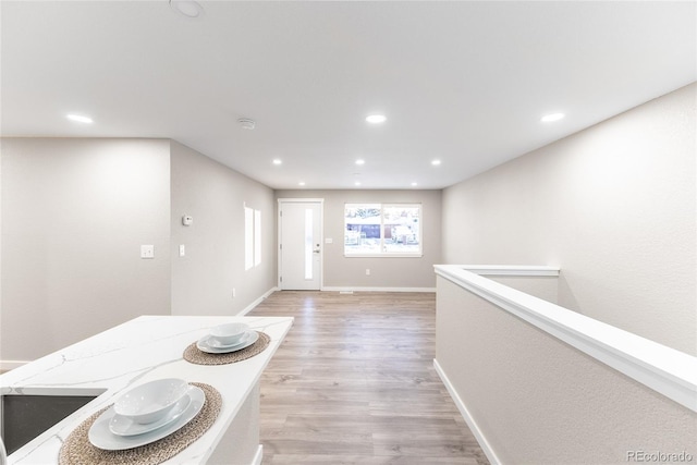 interior space featuring light wood-type flooring, baseboards, and recessed lighting