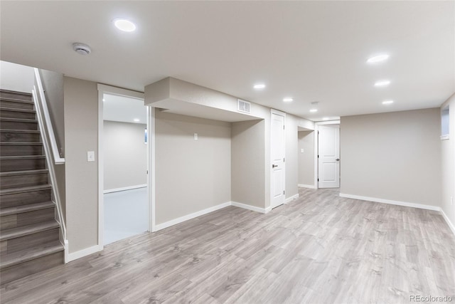 finished basement with recessed lighting, visible vents, light wood-style flooring, baseboards, and stairs