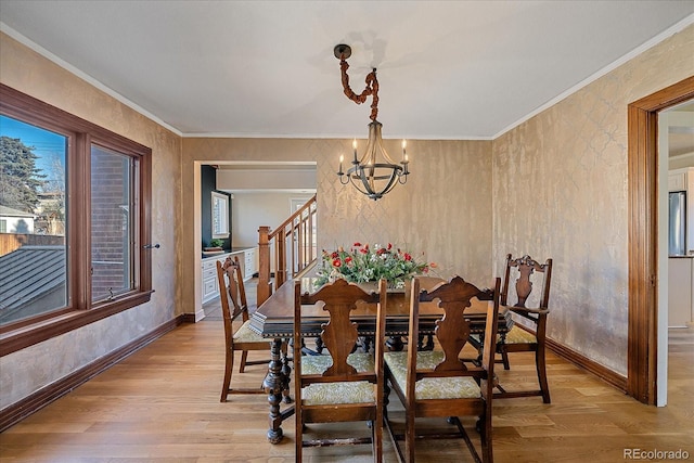 dining room featuring light hardwood / wood-style flooring, crown molding, and a notable chandelier