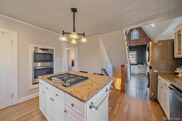 kitchen with decorative light fixtures, white cabinetry, and appliances with stainless steel finishes