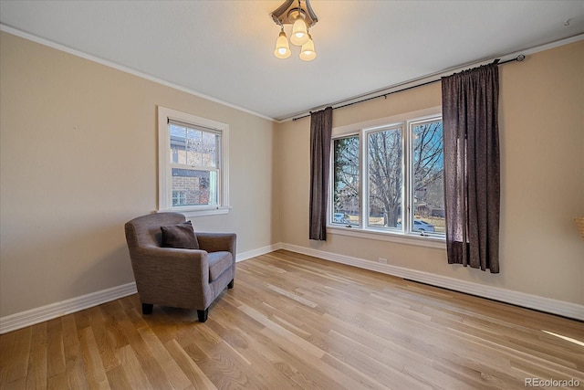 sitting room featuring light wood-type flooring and crown molding