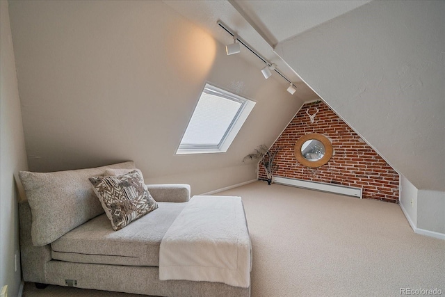 carpeted bedroom featuring rail lighting, lofted ceiling with skylight, and brick wall