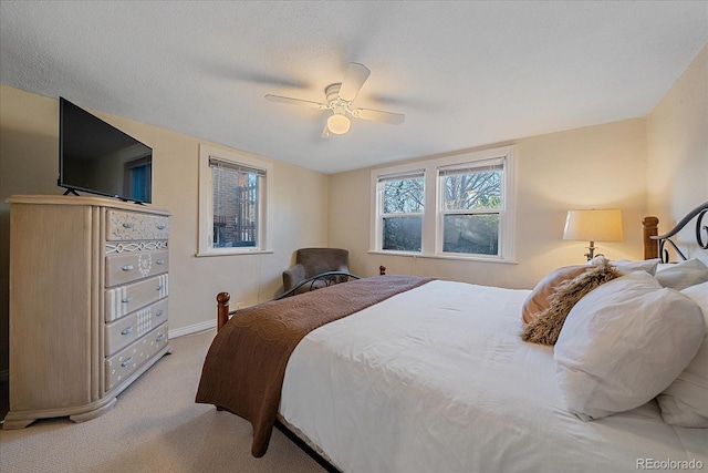 carpeted bedroom featuring a textured ceiling and ceiling fan