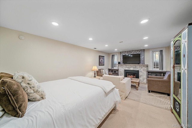 bedroom with light colored carpet and a brick fireplace