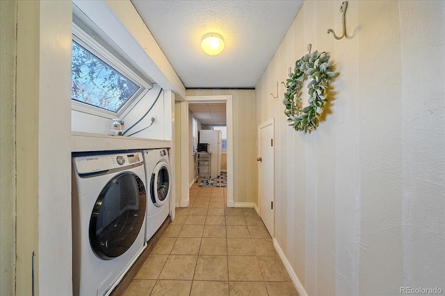 laundry room with light tile patterned floors, a textured ceiling, and washing machine and clothes dryer