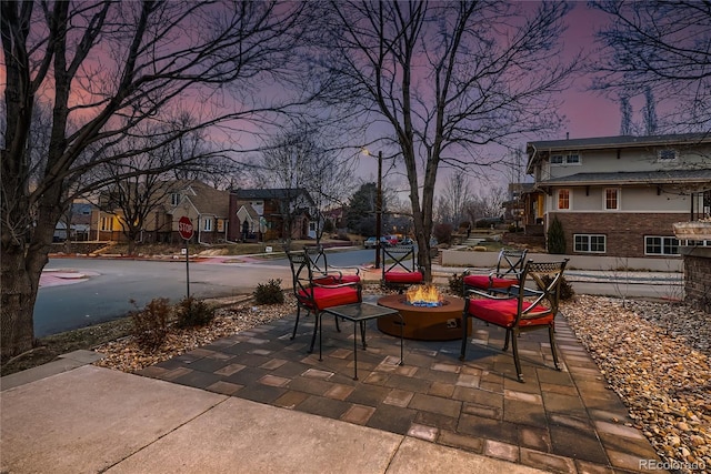 patio terrace at dusk featuring a fire pit