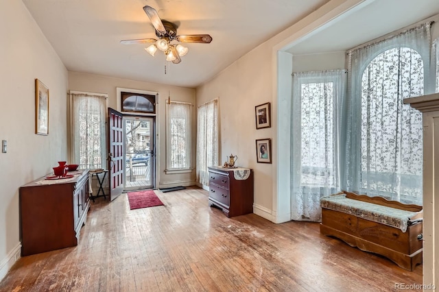 entryway featuring hardwood / wood-style flooring, baseboards, and ceiling fan