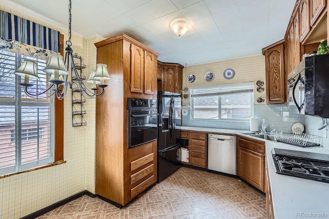 kitchen with black appliances, brown cabinetry, wallpapered walls, baseboards, and light floors