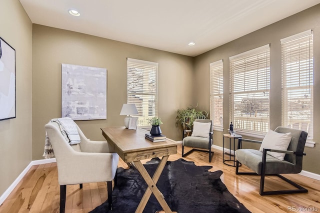 office space with plenty of natural light, baseboards, and wood finished floors