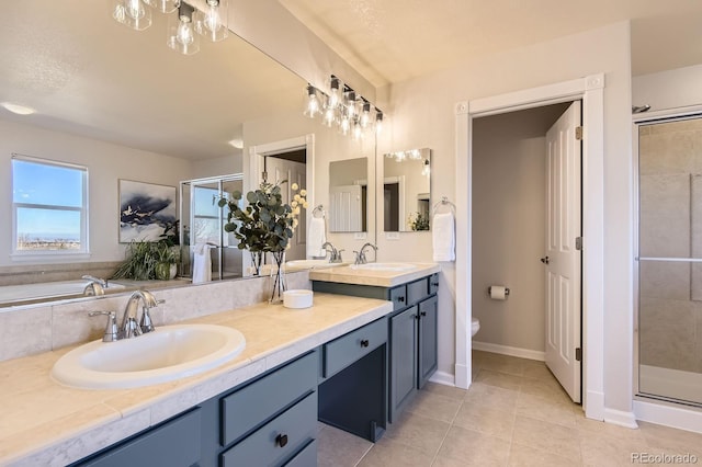 full bath featuring double vanity, tile patterned flooring, a stall shower, and a sink