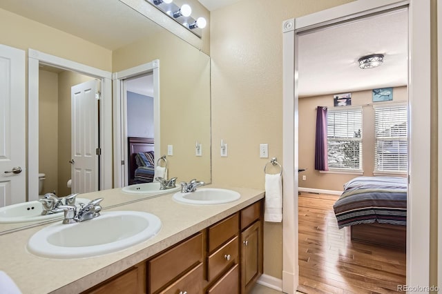 ensuite bathroom featuring a sink, hardwood / wood-style floors, and ensuite bathroom