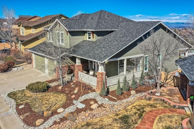 craftsman-style house with an attached garage, roof with shingles, a porch, and driveway