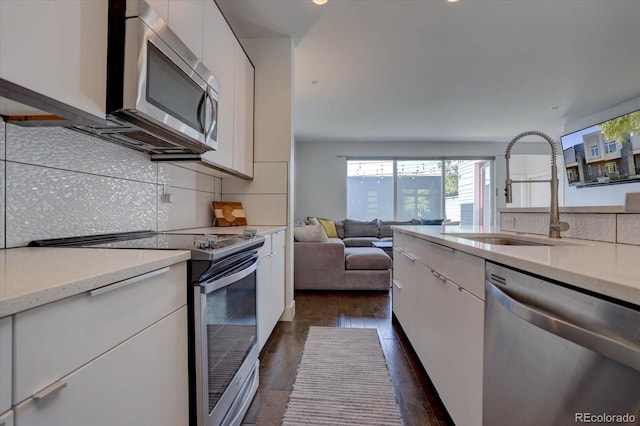 kitchen with white cabinets, stainless steel appliances, dark wood-type flooring, and sink