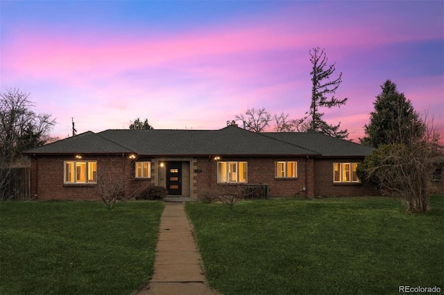 ranch-style home featuring a front lawn and brick siding