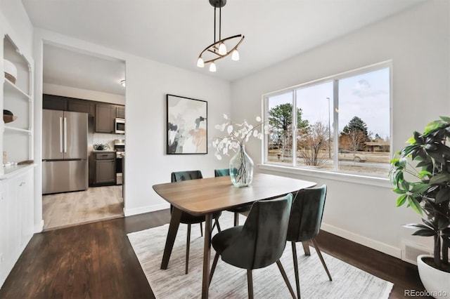 dining room with wood finished floors, visible vents, and baseboards