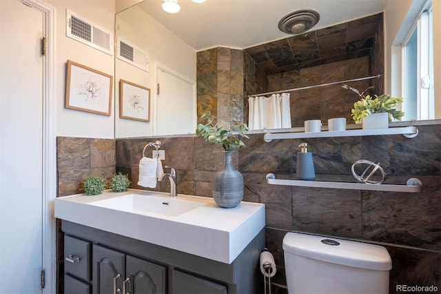 bathroom featuring tasteful backsplash, curtained shower, visible vents, and tile walls