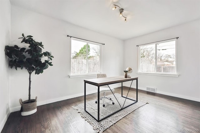 office with baseboards, track lighting, visible vents, and wood finished floors