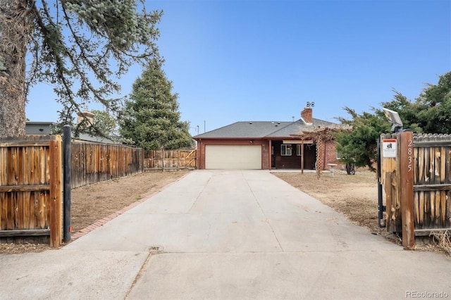 view of front of property with a garage, brick siding, fence, driveway, and a chimney