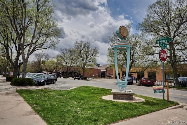 view of home's community with uncovered parking and a yard