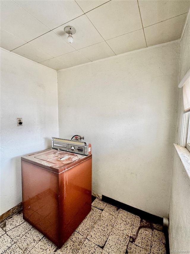 kitchen with light floors, baseboards, and a drop ceiling