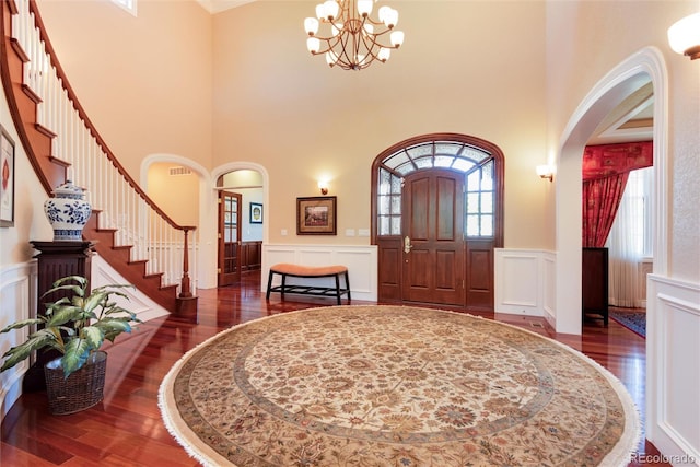 entrance foyer with a chandelier, dark hardwood / wood-style floors, and a towering ceiling