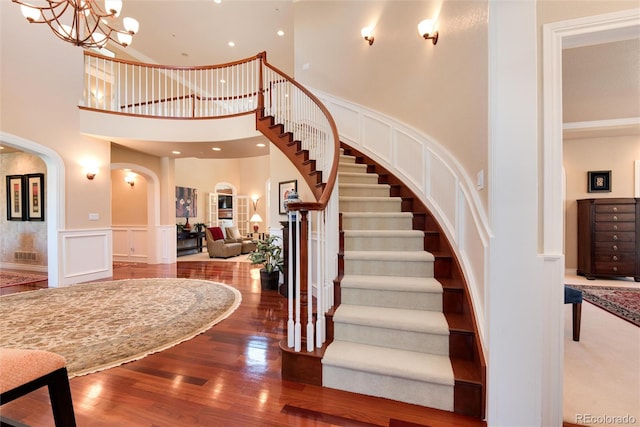 interior space with a high ceiling, a notable chandelier, and hardwood / wood-style flooring