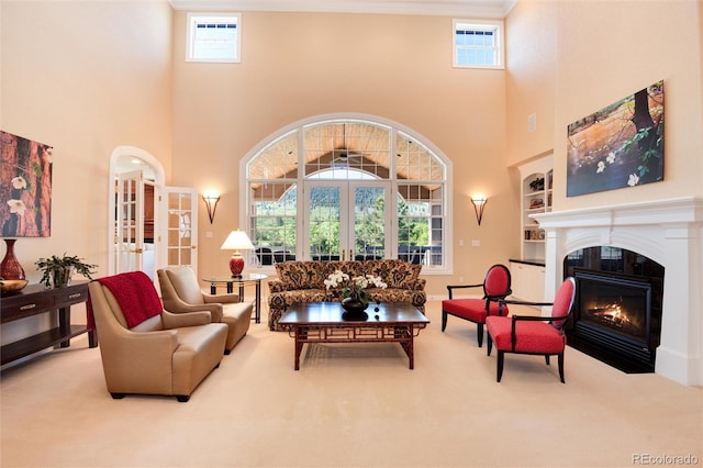 carpeted living room featuring built in shelves, french doors, and a high ceiling