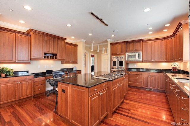 kitchen with pendant lighting, stainless steel appliances, dark hardwood / wood-style floors, and a center island