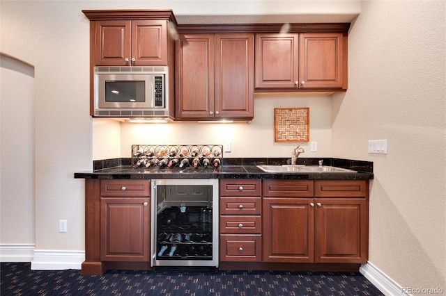 kitchen featuring stainless steel microwave, sink, and beverage cooler