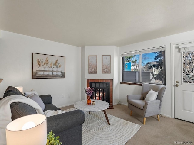 living area featuring baseboards, carpet flooring, and a tile fireplace