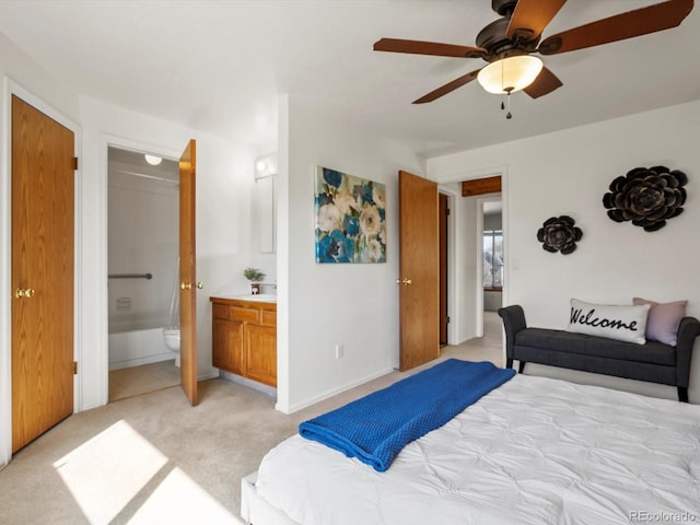 bedroom with light carpet, baseboards, ensuite bath, and ceiling fan